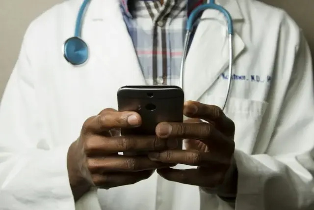 Doctor in a white coat using a smartphone