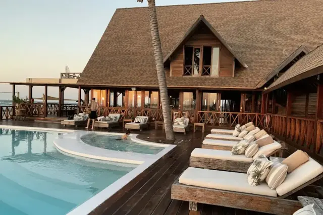 Hotel pool deck with sun loungers at sunset