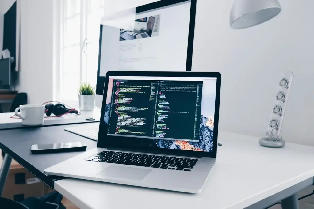 Laptop showing code on a bright, tidy desk